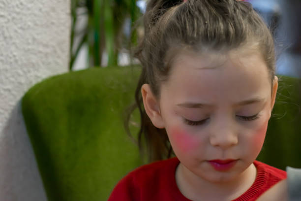Mother takes care of every detail while she does her daughter's makeup for a school event. The image highlights tenderness, maternal love and school preparation in a special moment.