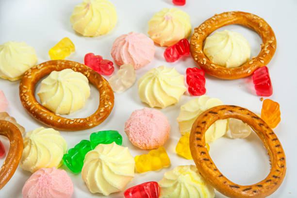 A white plate filled with pretzels and assorted candies, creating a colorful and enticing display.