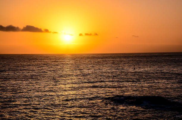 istock The sun is setting over the ocean, casting a warm glow on the water 2154770830