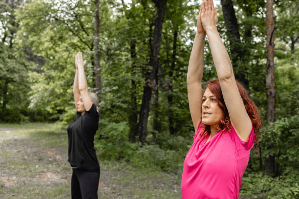istock Female friends practicing yoga at park 2154772408