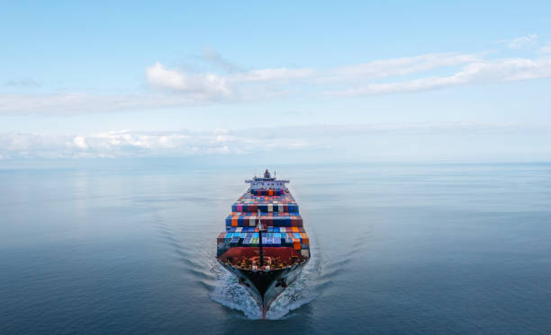 istock Aerial front view of a large container cargo ship travels over calm, blue ocean. 2154773055