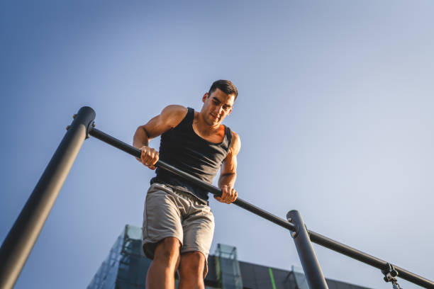 istock One man muscular male athlete training pull ups outdoor in sunny day 2154773073