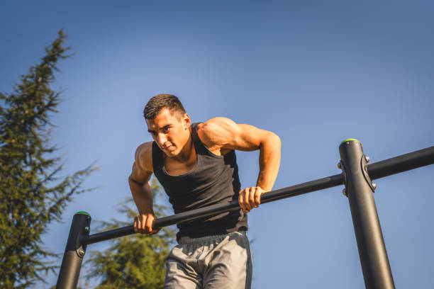 istock One man muscular male athlete training pull ups outdoor in sunny day 2154773087
