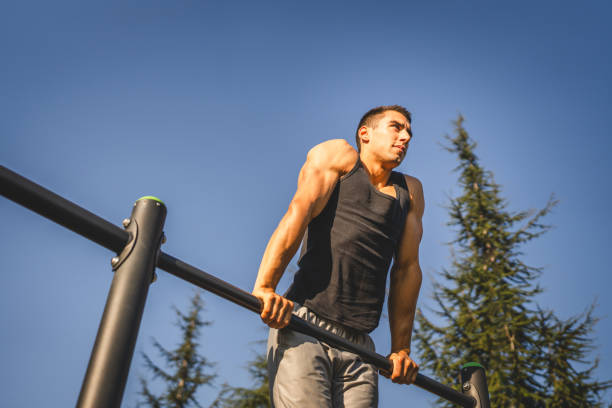 istock One man muscular male athlete training pull ups outdoor in sunny day 2154773482