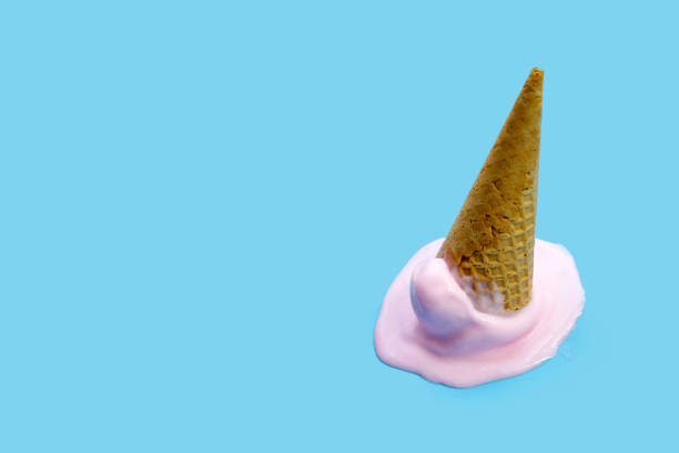 istock Melting ice cream balls with waffle cone on blue background. 2154774690