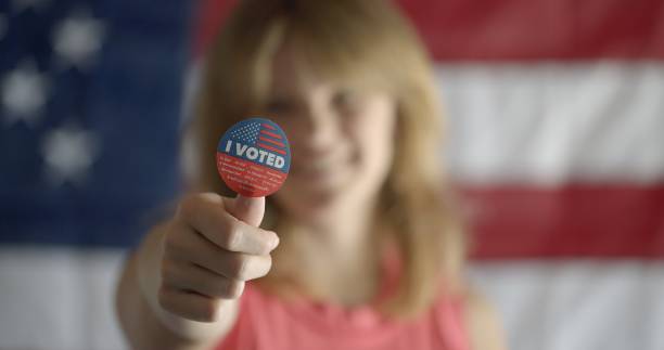istock CU young red-haired woman pushes I voted sticker forwards 2154775184