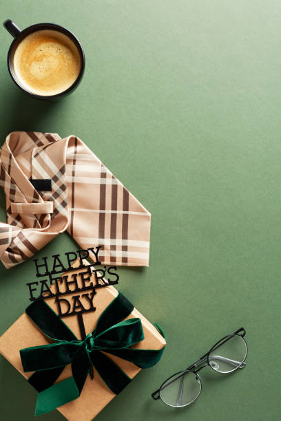 istock Happy Fathers Day vertical banner template. Vintage flat lay composition with gift box, coffee cup, tie, glasses on green background 2154784313