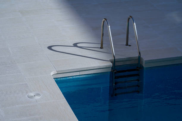 istock the shadow of a pool ladder is cast on the ground 2154784341