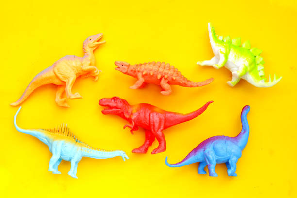 istock Plastic dinosaur toys on yellow background 2154785984