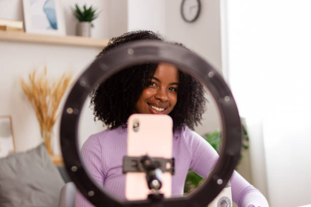 istock Smiling woman recording with smartphone and ring light 2154788787