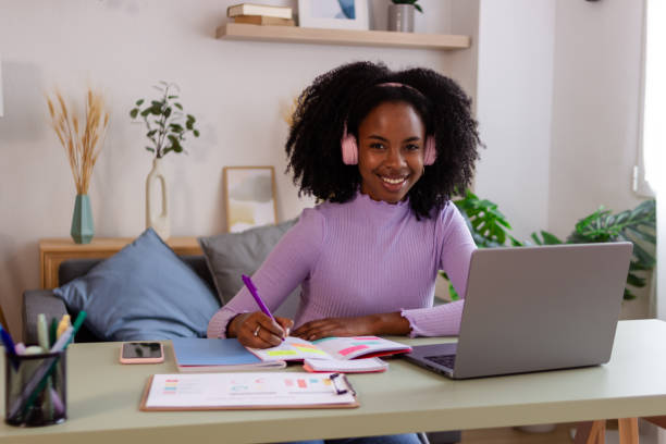 istock Smiling young woman studying at home 2154789344