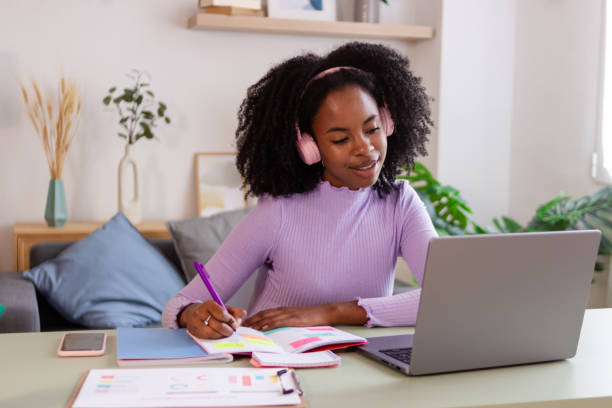 istock Smiling woman studying with laptop at home 2154789505