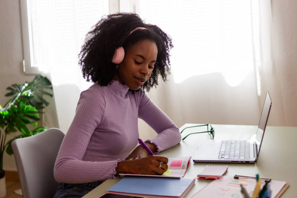 istock Young woman enjoying music while studying at home 2154789586