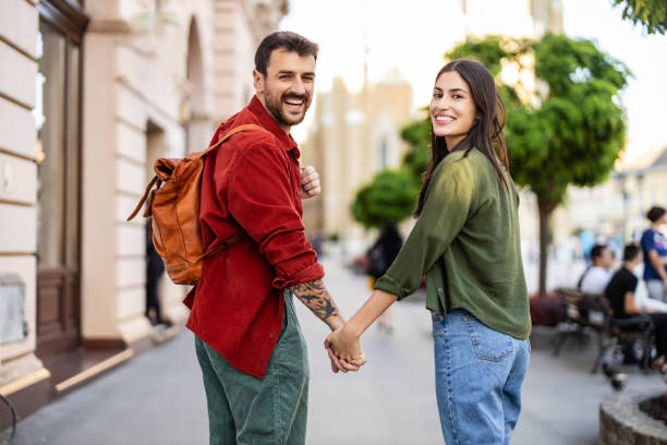 istock Playful couple holding hands in downtown area 2154789776