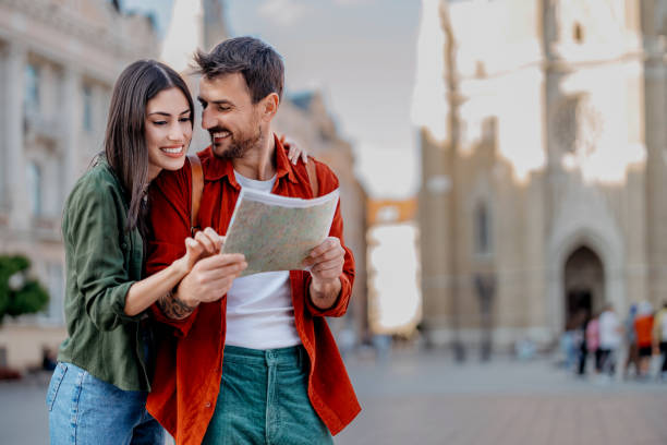 istock Couple with map smiling and pointing in city 2154790061