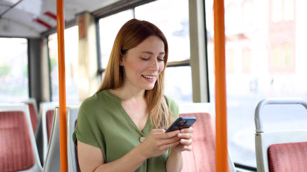 istock Happy young woman using smartphone while riding in a bus 2154791401