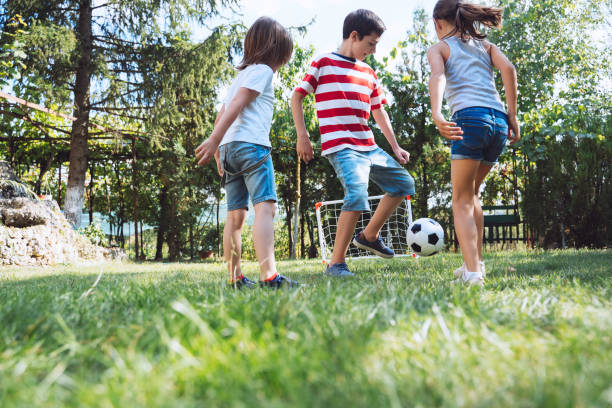 istock Kids playing with soccer ball in sunny park 2154792517