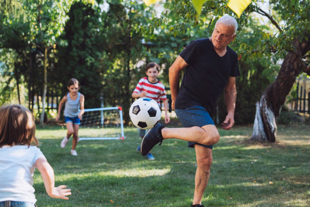 istock Senior man playing football with kids 2154792539