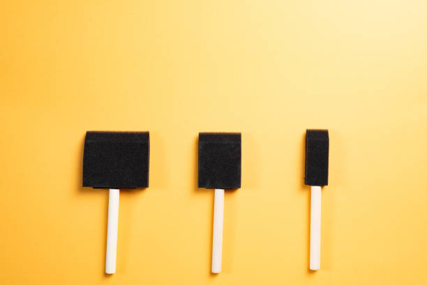 istock Foam sponge paint brush, black with wooden handle, yellow background. 2154795116