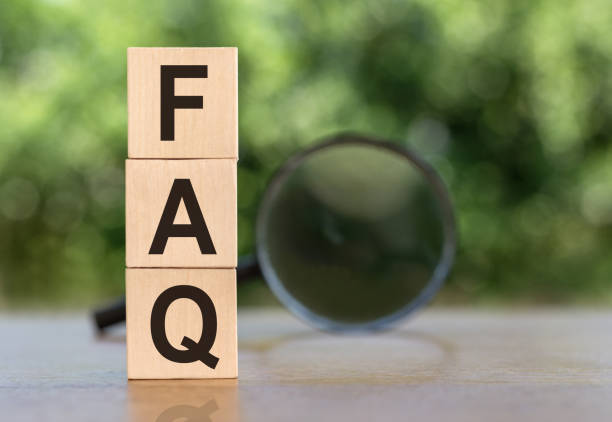 istock FAQ sign On Wooden Blocks on table with magnifier on green background 2154795356