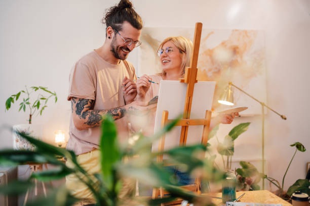istock Young smiling hipster couple painting together at creative studio. 2154795454