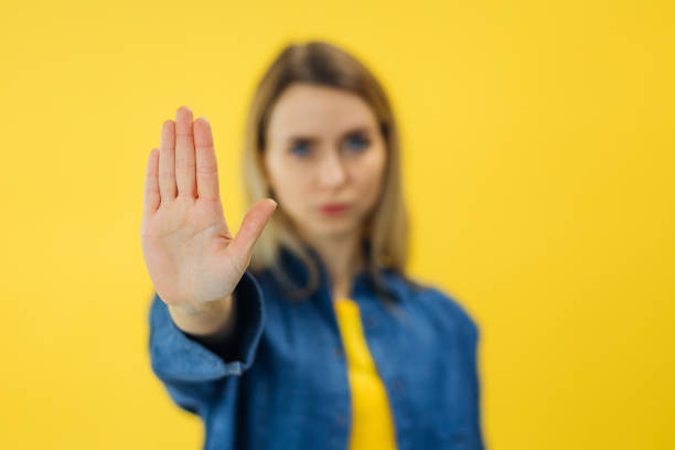 istock serious woman standing with outstretched hand showing stop gesture 2154796280