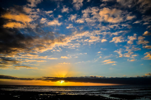 istock The sky is blue with a few clouds and the sun is setting 2154797742