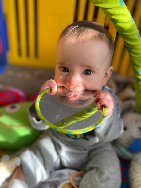 istock Baby boy chews on toy mirror 2154805518