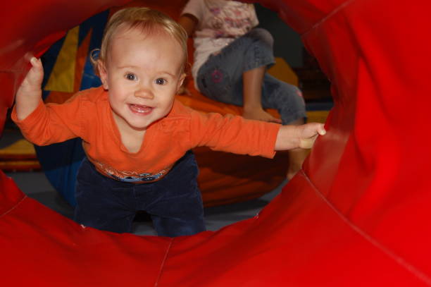 istock Toddler boy peering through tunnel 2154805523