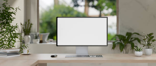 istock A computer with a white-screen mockup on a wooden table in a modern, minimalist living room. 2154805908