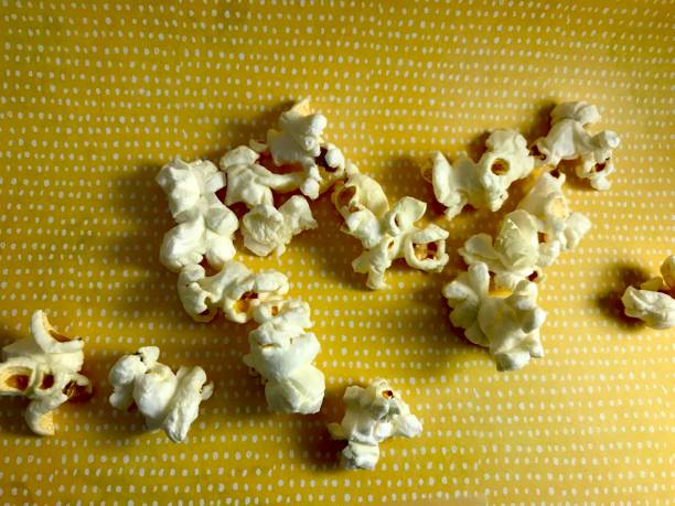 istock Close up of buttered pop corn snack on yellow and white polka dotted surface 2154806528