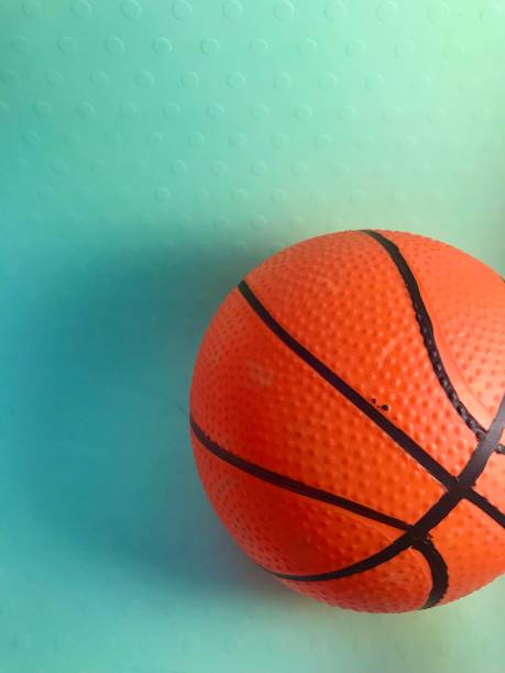 istock Orange and bumpy textured toy basketball on green surface 2154806539