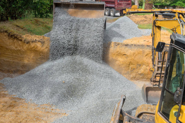 istock Excavator fills irregularities in excavations with granite rubble base that is then covered by concrete foundations in a construction site 2154806727