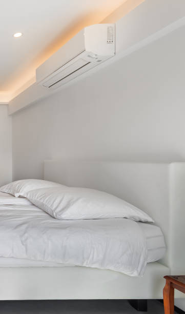 istock Air conditioner and bed in a white minimal style room. 2154807319
