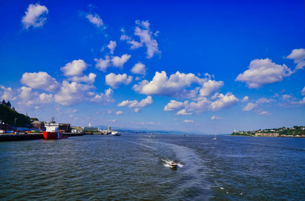 Cruise ships and pleasure boats on the St. Lawrence river in this wide angle view from a ferry on the river in Quebec city, the capital of Quebec province,Canada