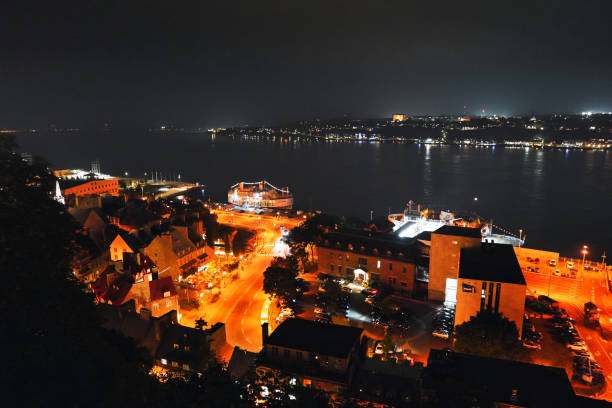 Night time view with Neon-washed lights of the Spanish enclave of Melilla with its modern commercial port. The city has a conspicuous breaker wall stretching 2 kilometers along the sea, to reduce the impact of storm .
