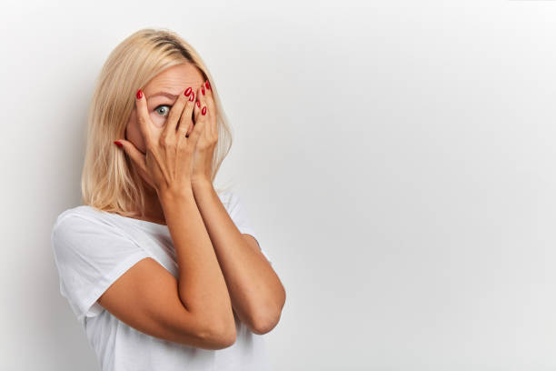 istock shocked, scared or frustrated young woman looking through fingers 2154817032