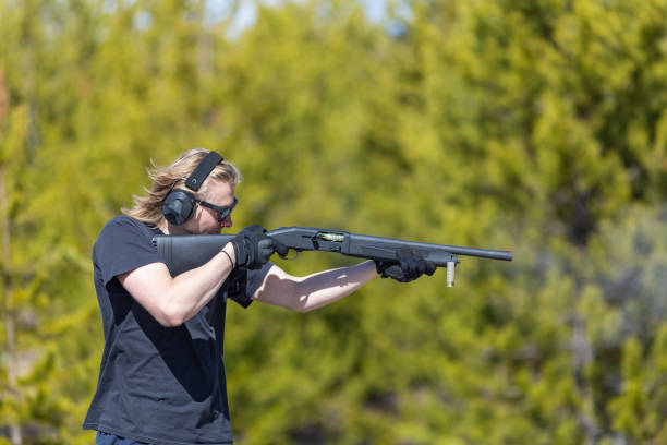 istock Young man shooting shotgun. 2154817624