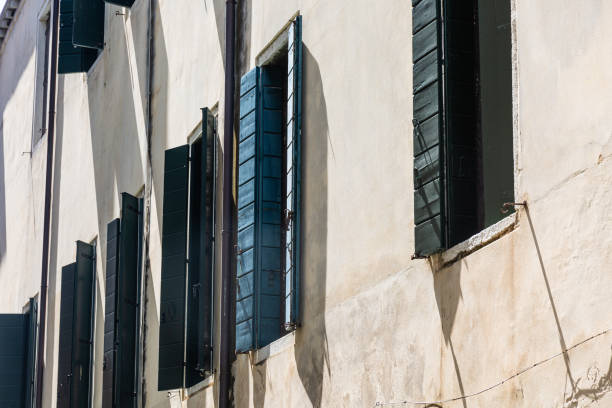 Old gothic Venetian building with decorative windows with shutters. Venice - 5 May, 2019