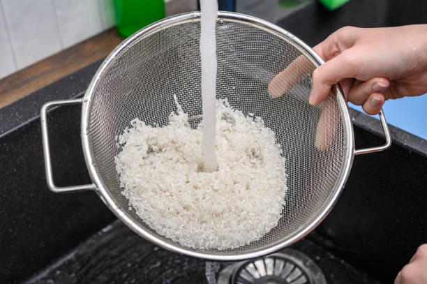 Washing white rice under running tap water