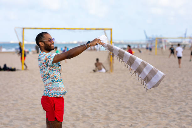 African man shakes sea raft to remove sand