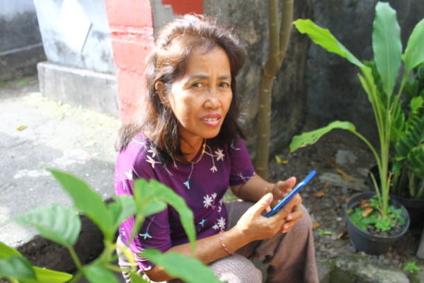 istock Asian woman using smartphone and looking at camera 2154828095