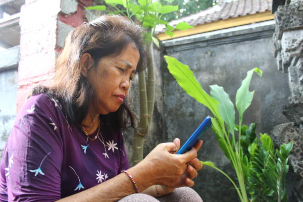 istock Asian woman sitting and using smartphone in the garden 2154828097