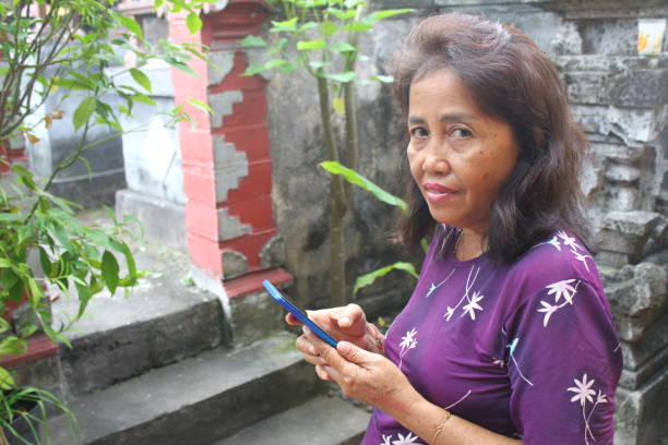 istock Asian woman using smartphone and looking at camera 2154828146