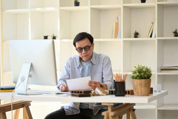 istock Focused senior architect in eyeglasses working on new project at modern office 2154828421