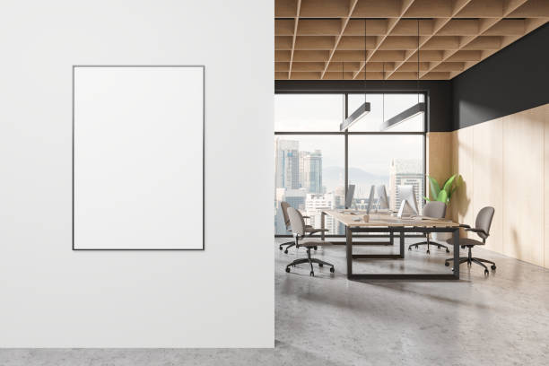istock A modern office interior with a blank poster on the wall, wood elements, and city view through large windows. 3D Rendering 2154828704