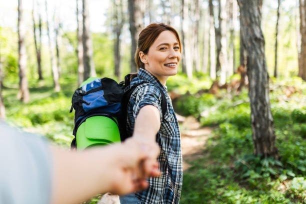 istock Young Woman Holding Boyfriend's Hand While Hiking 2154829237