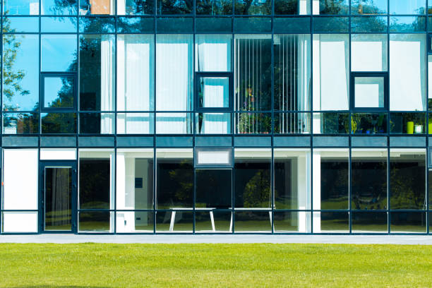straight square architecture design office building glass windows and walls exterior with green grass lawn order concept of modern environment space
