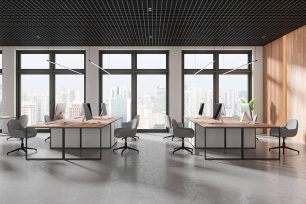 istock Stylish coworking interior with pc monitors on tables, panoramic window 2154830162