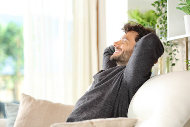 istock Happy man sitting on a couch relaxing 2154832138